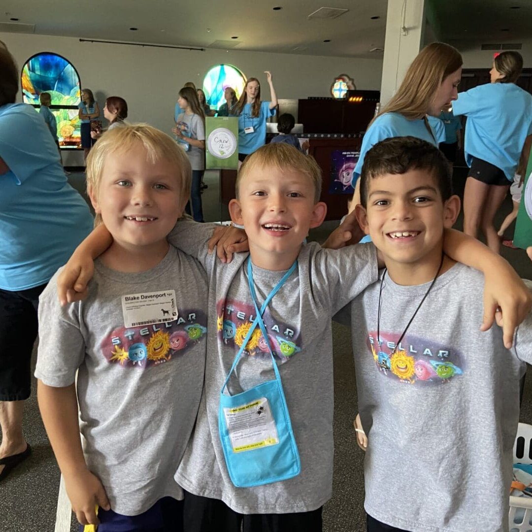 Three boys are posing for a picture at an event.
